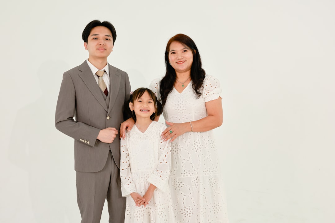 A family of three posing for a studio portrait.