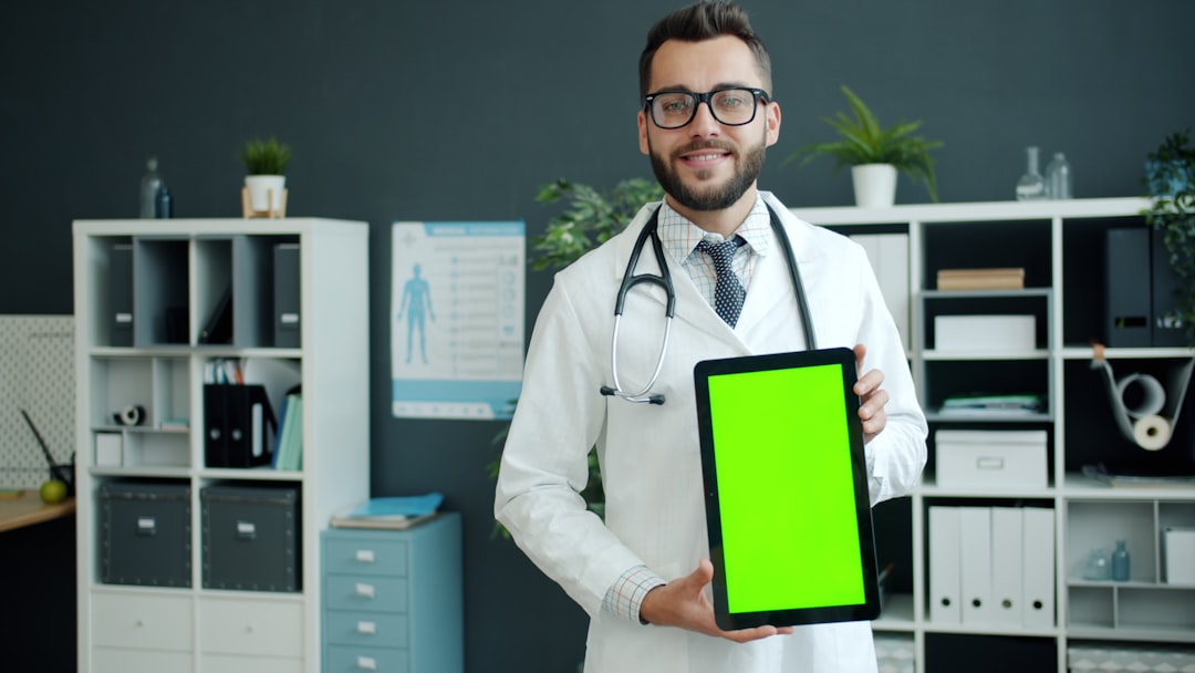 Doctor holding a tablet with a green screen.