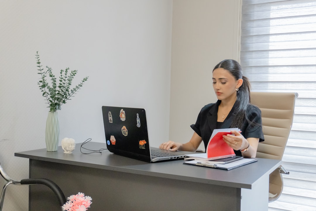 Woman working on a laptop at a desk.
