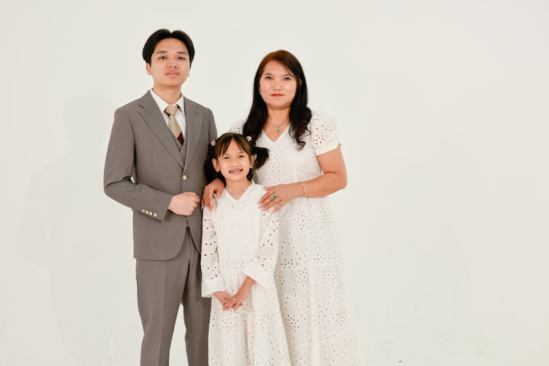 A family of three posing for a studio portrait.