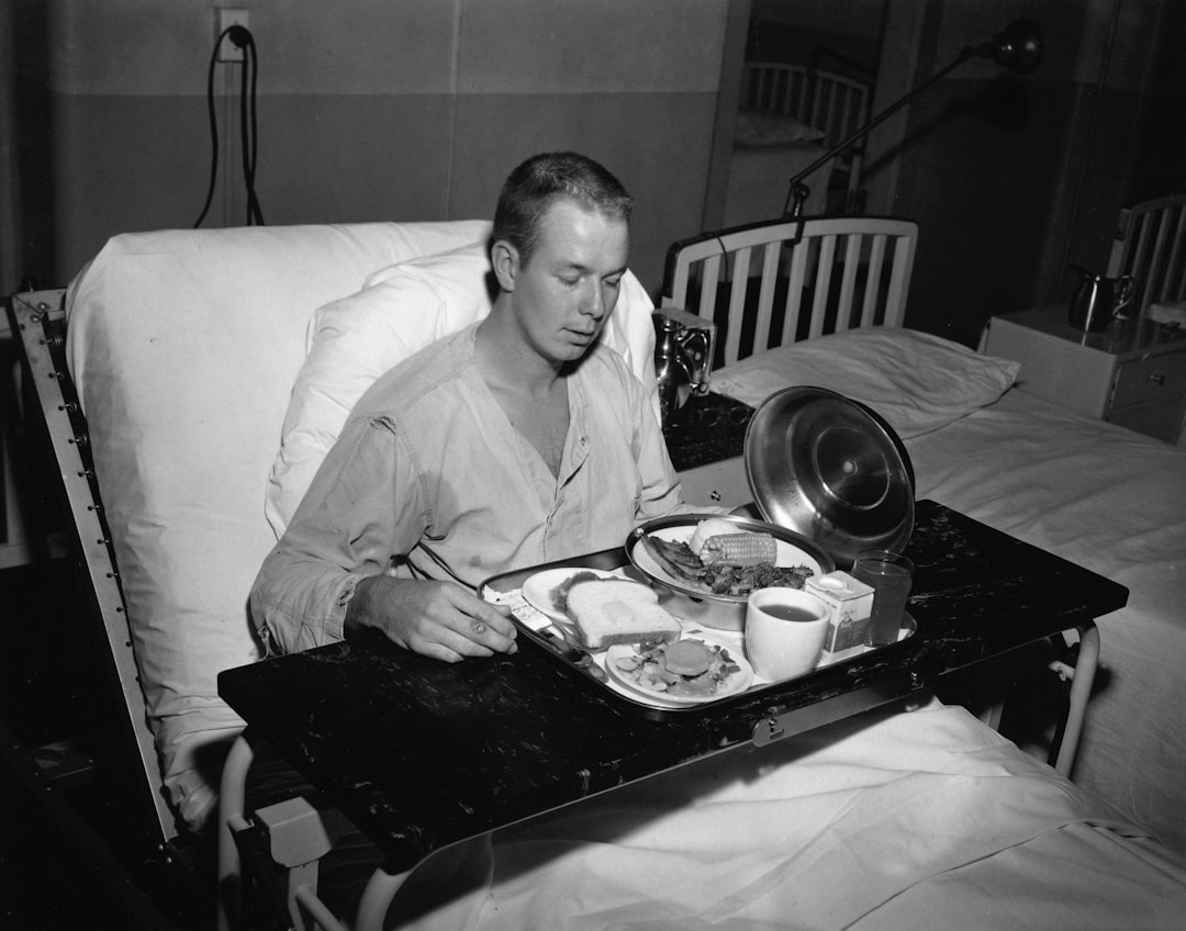 A man in a hospital bed eating a meal