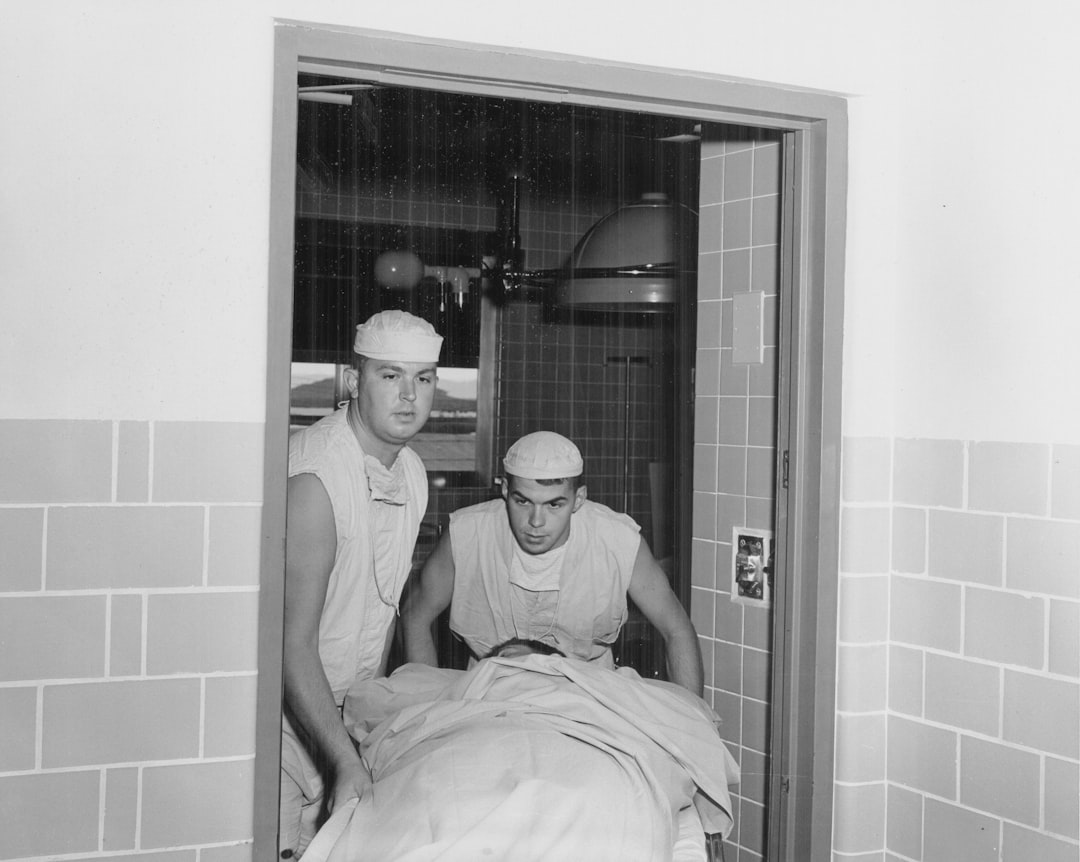 Two medical professionals transport a patient on a gurney.