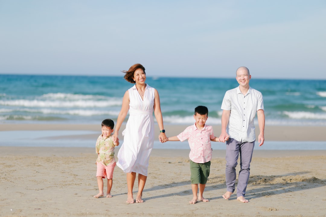 Family walking on a sandy beach by the ocean